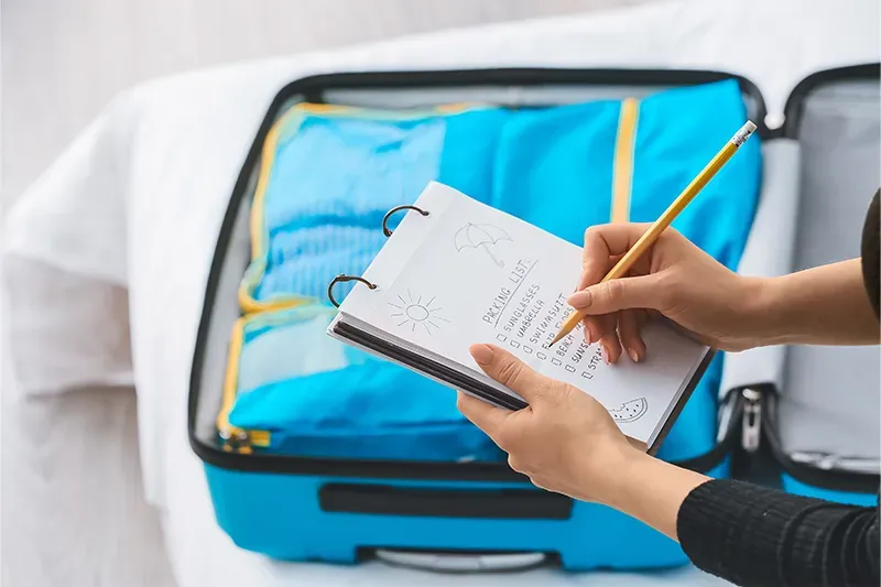 Close up of person writing a packing checklist